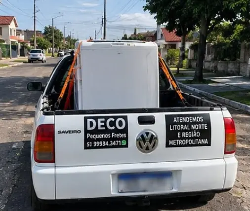 Vista traseira da Saveiro da Deco Fretes transportando uma geladeira